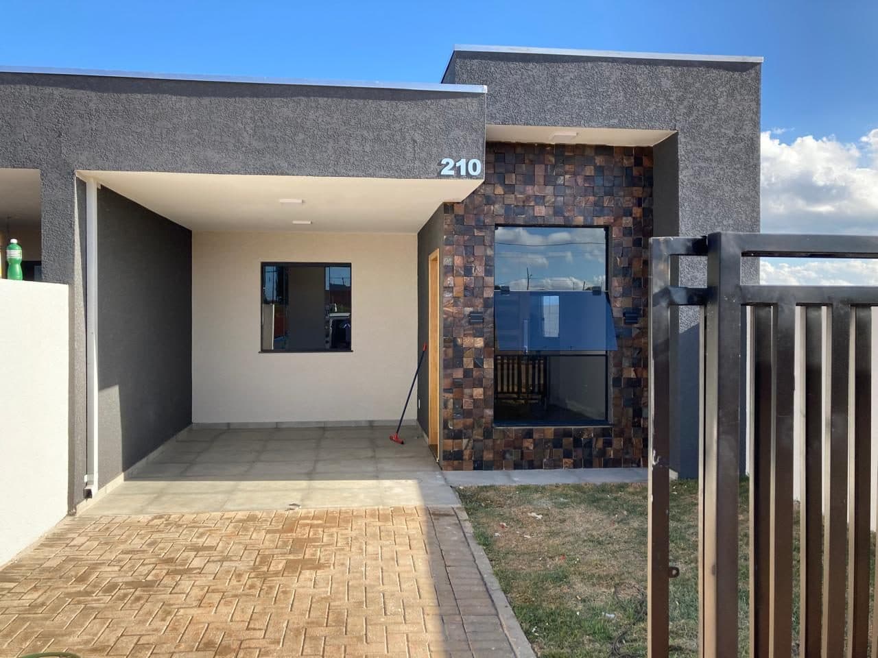 Fachada de casa entregue do Residencial Vila Marly, com garagem coberta e revestimento em pedra natural