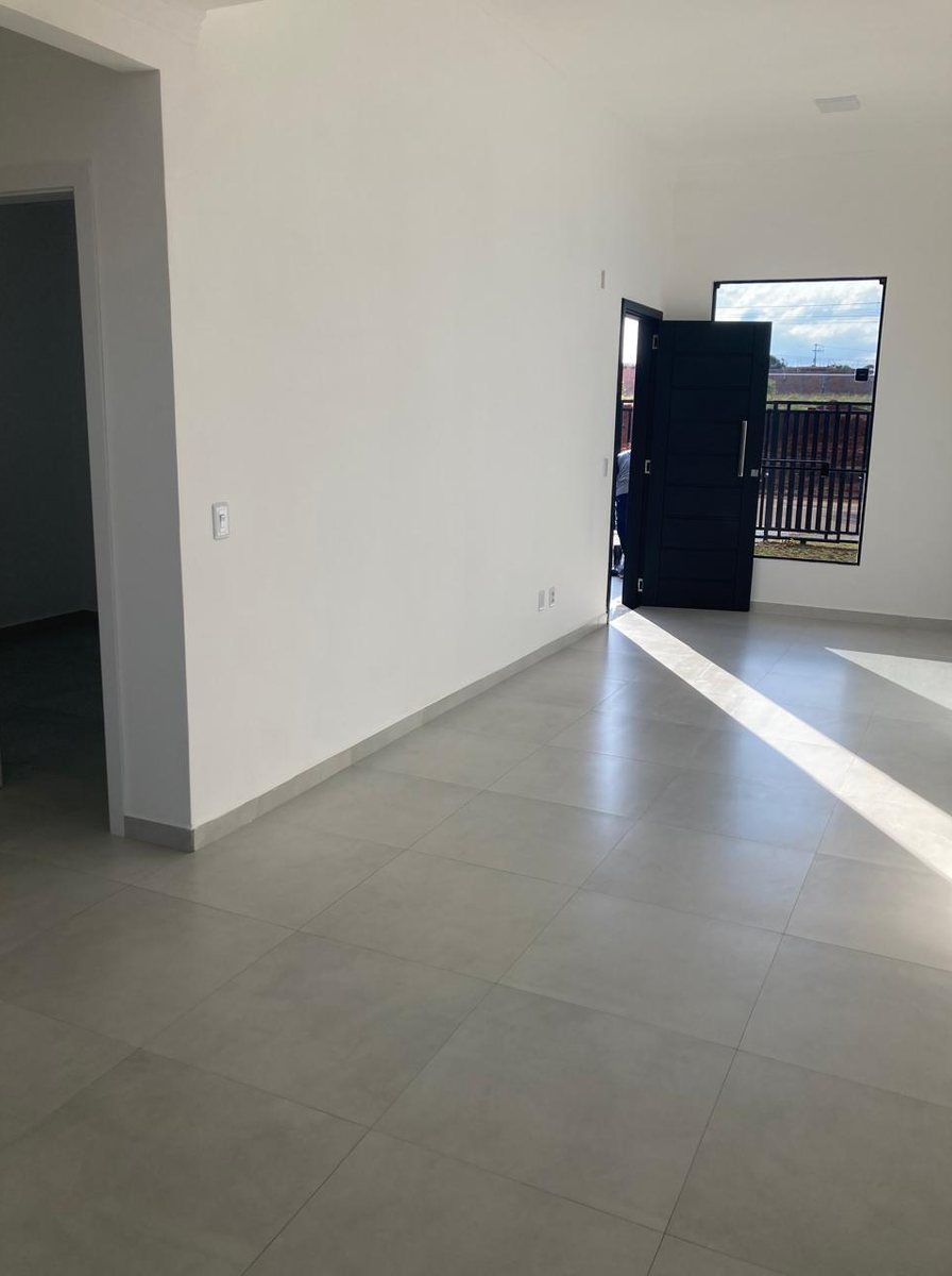 Hall de entrada de casa entregue, com porcelanato do piso e porta para o jardim